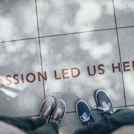 two people standing on grey concrete with writing which says 'passion lead us here'
